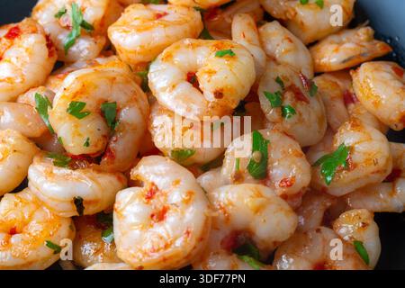 Crevettes grillées aux fruits de mer délicieuses - crevettes dans une sauce au beurre à l'ail avec citron et persil saupoudrées dans une poêle Banque D'Images