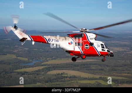 Vue air-air d'un hélicoptère PZL-Swidnik W-3A Sokol de l'armée de l'air tchèque, immatriculé 0714, numéro de série 370714, en opération pendant les jours OTAN 2025. L'hélicoptère à turbine bimoteur est doté d'un rotor principal à quatre pales, d'un rotor de queue et d'un train d'atterrissage rétractable. Utilisée pour le transport, la reconnaissance et la recherche et le sauvetage, l'image montre le fuselage, le cockpit, le rotor et la queue en vol de manœuvre pendant l'exposition aérienne de l'OTAN. Banque D'Images