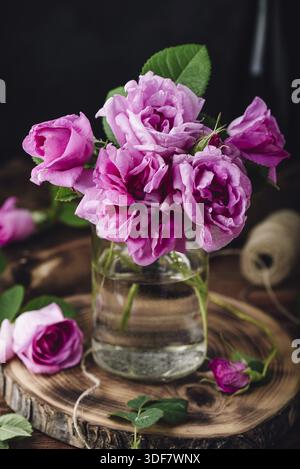 Bouquet de petites roses de jardin roses dans le vase sur la table Banque D'Images