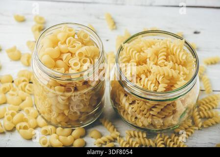 Deux sortes de pâtes de blé entier italien dans des bocaux en verre Banque D'Images