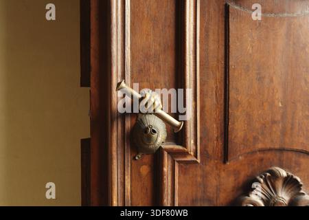Porte massive avec une poignée de porte en forme de main Banque D'Images