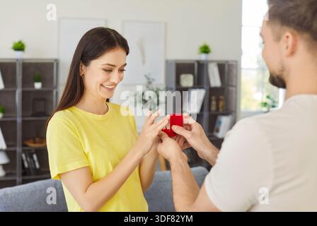 Homme tenant la boîte de bague proposant à sa petite amie bien-aimée dans le moment romantique Banque D'Images