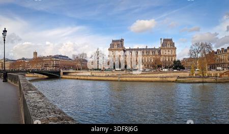 Belle vue panoramique sur l'Hôtel de ville depuis la Seine, montrant la grande façade néo-Renaissance et les berges bordées d'arbres Banque D'Images
