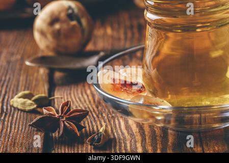 Thé arabe avec l'anis étoilé, de cardamome et de chaux séchée sur surface en bois verre oriental Banque D'Images