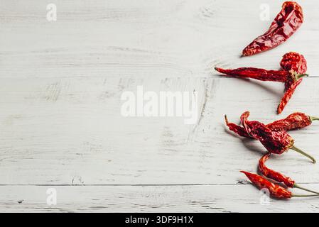 Piments rouges séchés sur fond de bois clair Banque D'Images