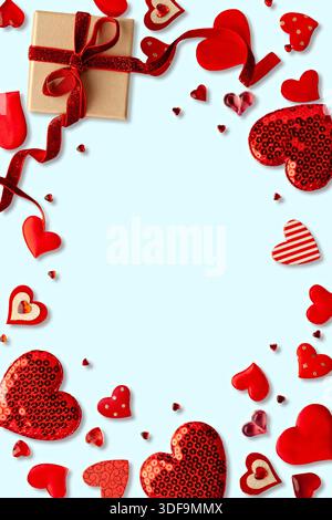 Cadre romantique de Saint-Valentin avec cœurs rouges et boîte-cadeau sur fond bleu clair Banque D'Images