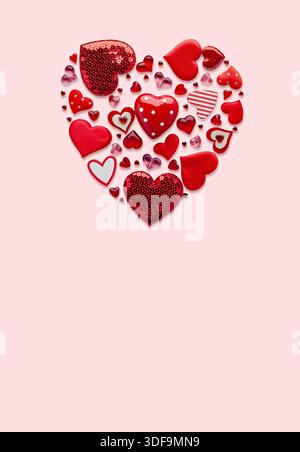 Arrangement en forme de coeur de décorations rouges sur fond rose pour la Saint-Valentin Banque D'Images
