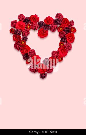 Arrangement de Rose en forme de coeur sur fond rose doux pour des occasions romantiques Banque D'Images