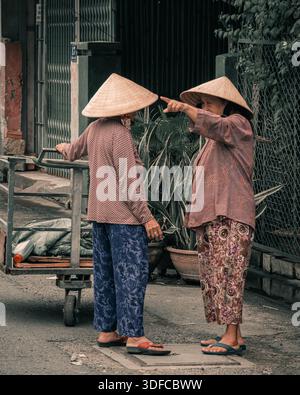 Nha Trang, Vietnam, 27 septembre 2025. Deux vietnamiennes âgées discutant dans la rue Banque D'Images