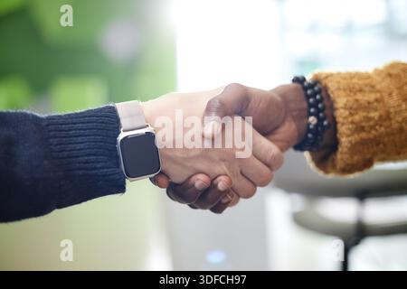 Caucasien jeune homme adulte et Noir jeune homme adulte serrant la main à l'intérieur Banque D'Images