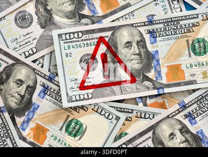 Panneau d'avertissement rouge sur les billets de cent dollars des États-Unis indiquant les risques financiers et les problèmes économiques Banque D'Images