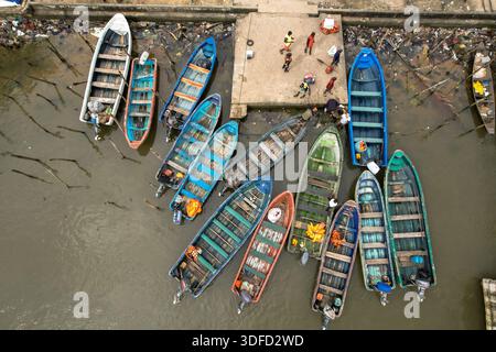 Vue aérienne de bateaux colorés amarrés à la jetée près d'une zone animée avec des gens et des objets dispersés, Opobo, Rivers, Nigeria. Banque D'Images
