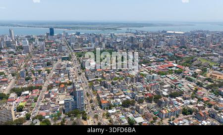 Vue aérienne d'un paysage urbain animé avec des bâtiments imposants, des espaces verts vibrants, et un pont lointain s'étendant sur l'eau, Maputo, Cidade de Banque D'Images