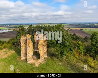 Les ruines de la chapelle de l'exaltation de la Sainte Croix se dressent au milieu d'une végétation luxuriante à Bristev, capturées d'en haut par un drone par temps clair. Des champs pittoresques s'étendent en arrière-plan. Banque D'Images