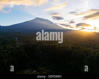 Lever de soleil sur une forêt tropicale luxuriante avec un majestueux mont Agung, Karangasem, Bali, Indonésie, montagne en arrière-plan. Banque D'Images