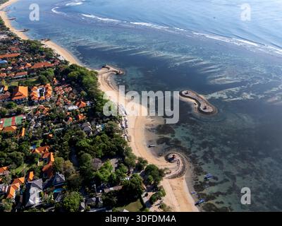 Vue aérienne drone de la côte de la station balnéaire de Sanur Beach, Bali, montrant des villas de luxe, des hôtels et l'océan Indien turquoise avec plage unique Banque D'Images