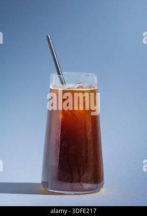 Boisson au café glacé préparée avec du café noir superposé sur du jus d'orange et servie sur de la glace dans un verre transparent. Boisson rafraîchissante au café aux agrumes. Banque D'Images