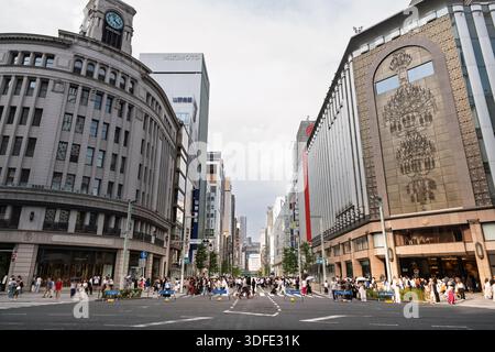 Tokyo, Japon - 09 août 2025 : rue ginza remplie de piétons traversant sous des bâtiments modernes, mettant en valeur l'architecture diversifiée et la ville dynamique Banque D'Images