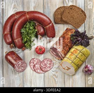 Différents types de saucisses avec des légumes sur une table en bois Banque D'Images