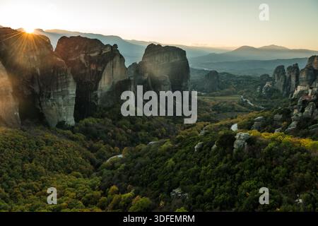 Vue de la lumière du soleil se répand sur des formations rocheuses spectaculaires et des forêts verdoyantes dans un paysage d'anciens monastères, Trikala, Thessalie, Grèce. Banque D'Images