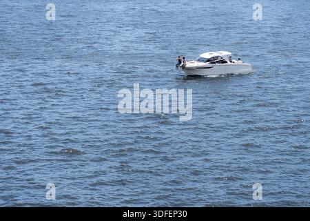 Vue d'un bateau blanc glisse à travers l'étendue ondulante de l'eau bleue, transportant des passagers sous le ciel ouvert, une scène maritime sereine, Tokyo, Tokyo, Banque D'Images