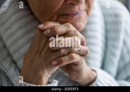 Femme âgée reposant sa tête sur ses mains, gros plan Banque D'Images
