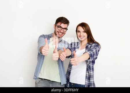 Couple drôle avec le pouce vers le haut geste, prise de vue en studio Banque D'Images