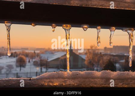 Aube hivernale. Icicle dans les rayons du soleil du matin. Paysage urbain. Temps froid. Matin glacé. Eau dure. Motifs de glace. Beauté de la nature. Banque D'Images