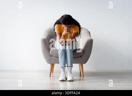 Problèmes de la vie. Portrait de la dame désespérée assise avec la tête vers le bas dans le fauteuil Banque D'Images