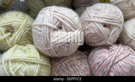 Boules de fil dans des tons pastel doux gros plan, idéal pour l'artisanat et le tricot de fond. Photo mobile Banque D'Images