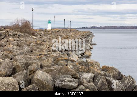Prescott front de mer et phare sur le fleuve Laurent en Ontario, Canada. Petit phare derrière la jetée rocheuse sous le ciel couvert. Banque D'Images