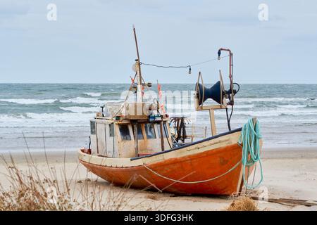 Bateau de pêche artisanale reposant sur la plage de Cabo Polonio, Uruguay. Le navire montre des signes d'usure, avec les engrenages et les cordes exposés, sous un s couvert Banque D'Images