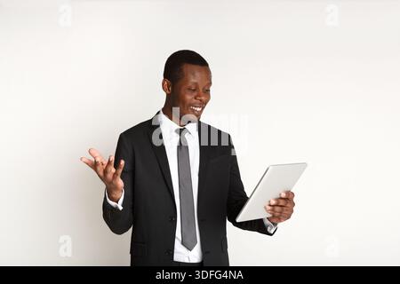 Homme d'affaires afro-américain souriant à l'aide de la tablette. Banque D'Images