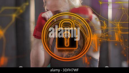 Tenant la femme levant les poings dans le gymnase, portant un haut sans manches, des enveloppements de mains rouges et des circuits de verrouillage orange Banque D'Images