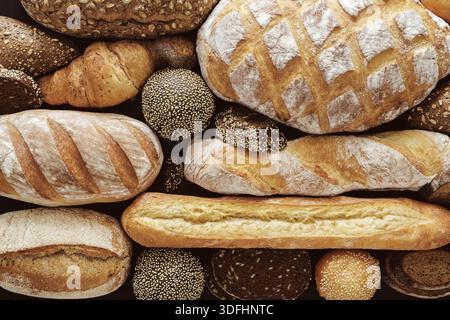 Assortiment de pains présentés sur une surface en bois rustique pour une vitrine de boulangerie Banque D'Images