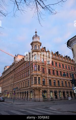 Vue captivante sur un bâtiment historique de la ville européenne, présentant des détails architecturaux complexes et une charmante tourelle d'angle sous un ciel doux. Banque D'Images
