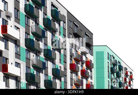 Immeuble contemporain avec une façade colorée dans un style minimaliste. L'extérieur combine des panneaux gris, blanc, turquoise et orange avec audacieux Banque D'Images