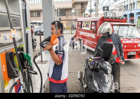 Des travailleurs de stations-service font le plein de motocyclettes dans une station de Cebu, Philippines Banque D'Images