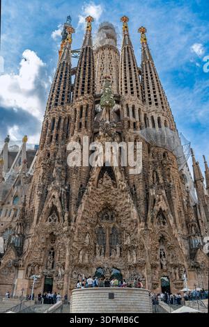 Barcelone, Espagne - 19 octobre 2025 : vue en bas angle de l'imposante façade de la Nativité de la basilique de la Sagrada Familia sous un ciel bleu. Banque D'Images
