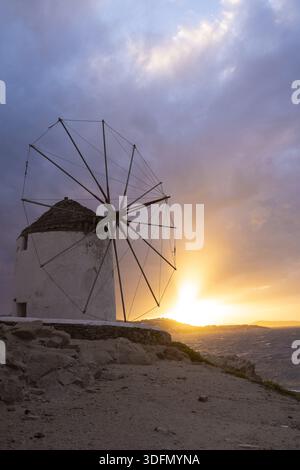 Vue de l'emblématique moulin à vent de Mykonos silhouette contre le coucher de soleil radieux, projetant une lueur chaude sur le paysage, Mykonos, Mykonos, Grèce. Banque D'Images