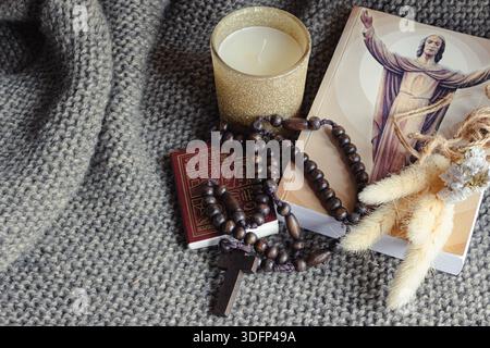 Foi et offrande de prière, montrant un chapelet en bois avec une croix sur un fond de couverture tricotée Banque D'Images