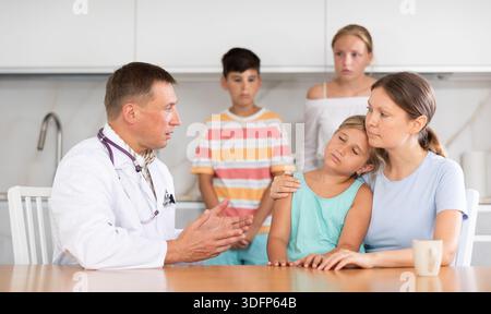 Visite du médecin de famille masculin à domicile. Médecin examinant les enfants Banque D'Images