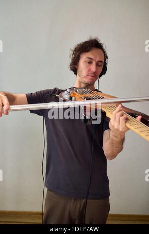 Performance basse puissante, performeur dynamique communiquant passionnément par le biais de la guitare basse, musicien aux cheveux bouclés immergé dans des basses expressives Banque D'Images