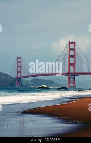 Golden Gate Bridge vu d'une plage de sable avec des vagues. Banque D'Images