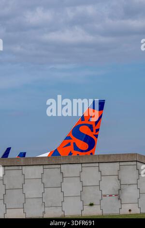 Minneapolis, Minnesota. Aéroport international MSP. La queue d'un avion Sun Country contre un ciel bleu. Banque D'Images