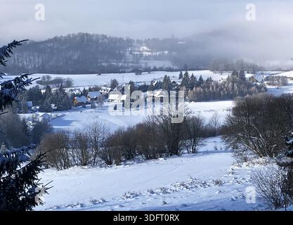 Paysage d'hiver avec chalet dans joli village en montagne Banque D'Images