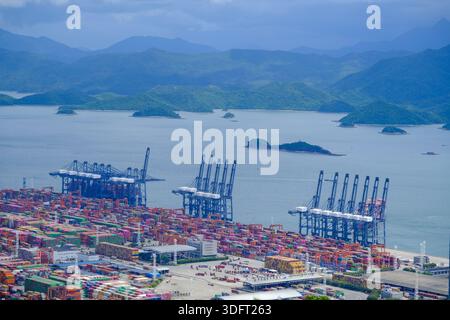 Une vue panoramique panoramique capturant l'immense échelle d'un terminal à conteneurs moderne, avec plusieurs grues à portique imposantes et une stacke dense Banque D'Images
