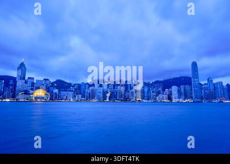 Une vue panoramique spectaculaire et grand angle sur les gratte-ciel de Hong Kong à travers le port Victoria au crépuscule ou au crépuscule. Banque D'Images