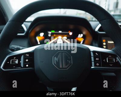 Gros plan d'un volant de voiture MG et d'un tableau de bord numérique avec commandes intérieures modernes. Banque D'Images