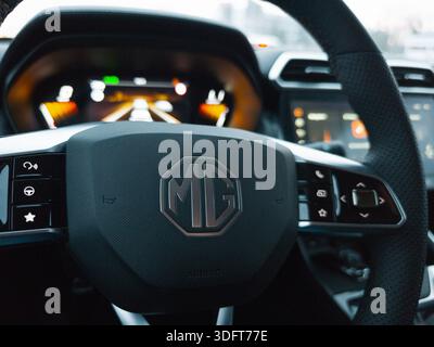 Gros plan d'un volant de voiture MG et d'un tableau de bord numérique avec commandes intérieures modernes. Banque D'Images